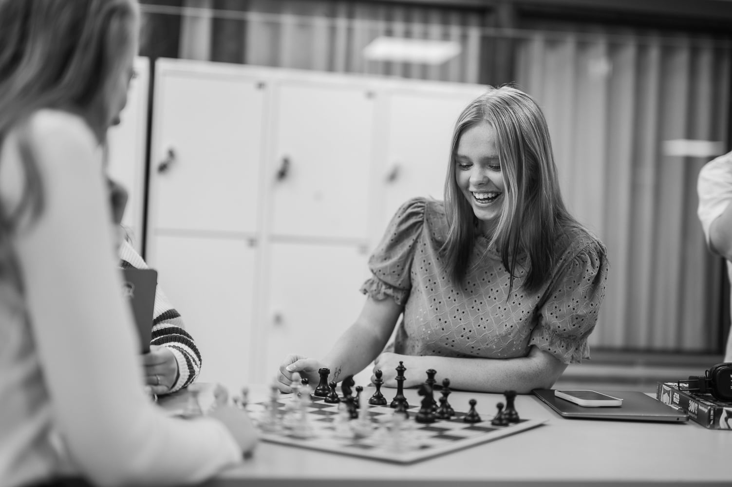 Två elever spelar schack, svartvitt.